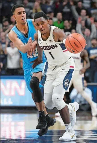  ?? JESSICA HILL/AP PHOTO ?? UConn’s Christian Vital steals the ball from Columbia’s Nate Hickman, left, during the second half of the Huskies’ 77-73 overtime win on Wednesday night at Gampel Pavlion. Vital led UConn with 29 points.