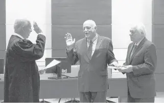  ?? JOE CAVARETTA/SOUTH FLORIDA SUN SENTINEL ?? New Broward Supervisor of Elections Peter Antonacci, center, is sworn into office by Chief Judge Jack Tuter while former Florida Attorney General Bob Butterwort­h holds the Bible at the Broward County Courthouse on Thursday.