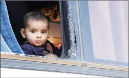  ?? (AFP) ?? A Syrian child looks outside a bus carrying Jaish al-Islam fighters and their families from the former rebel bastion’s main town of Douma, as they arrive at the Abu al-Zindeen checkpoint controlled by Turkish-backed rebel fighters near the northern...