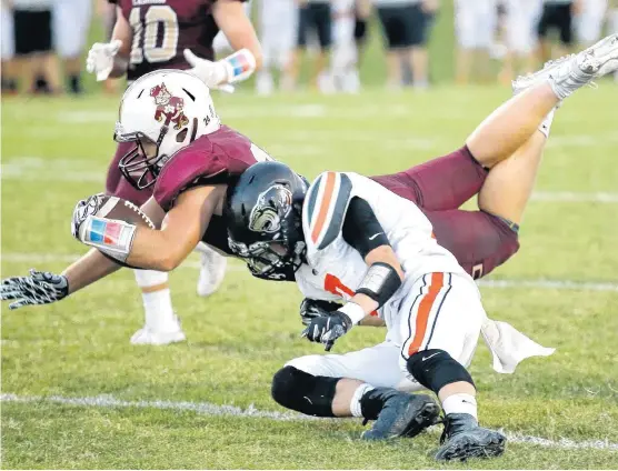  ?? [PHOTO BY SARAH PHIPPS, THE OKLAHOMAN] ?? Cashion’s T.J. Roberts dives for a touchdown as Crescent’s Trystin Roles defends during Friday’s football game in Cashion.