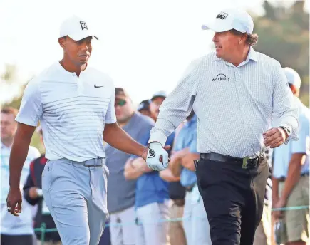  ??  ?? Tiger Woods and Phil Mickelson teamed up during Masters practice round Tuesday.