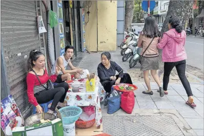  ?? [AMANDA MUSTARD/THE NEW YORK TIMES PHOTOS] ?? Nguyen Thu Hong, a street vendor, sells a tofu and noodle dish called “bun dau” from the sidewalk in Hanoi. Major cities in Vietnam, Thailand and Indonesia are strengthen­ing campaigns to clear the sidewalks, driving thousands of food vendors into the...