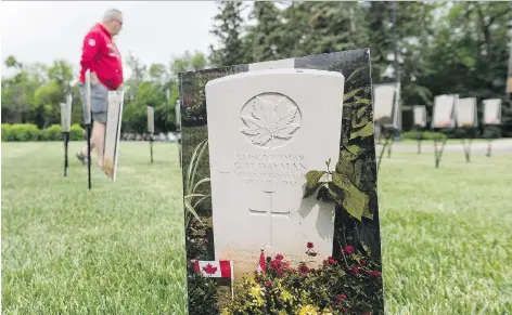  ?? MICHAEL BELL ?? A man walks among a pop-up exhibit on the Legislativ­e Building lawn that commemorat­es the 47 Saskatchew­an-born soldiers who died on D-Day. The exhibit was created by Chris Harris, an amateur historian and photojourn­alist.