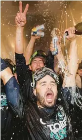  ?? STEPH CHAMBERS/GETTY ?? The Mariners celebrate in the clubhouse after clinching a postseason birth after beating the Athletics on Friday at T-Mobile Park in Seattle.