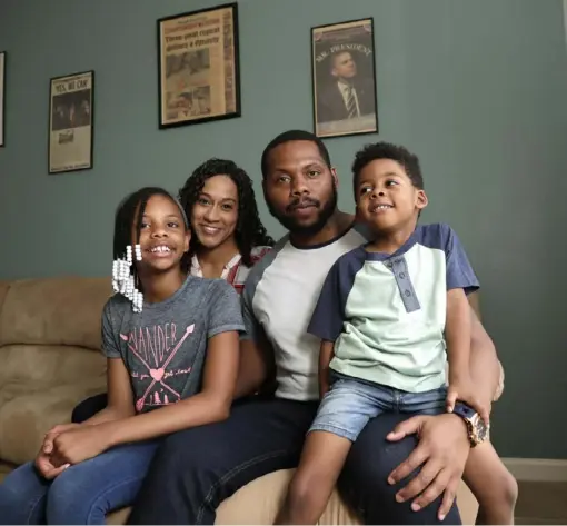  ?? Associated Press ?? D.J. Boldin poses with his children Madison, 10, left, and Dallas, 4, right, and fiancee, Sasha Jones, at their home in Miramar, Fla. Boldin, the football coach at Pahokee High School, is using his position to help guide the next generation of young men.