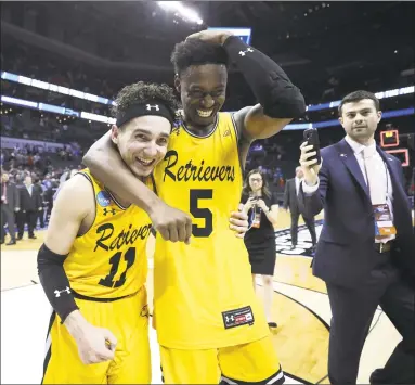  ?? Streeter Lecka / Getty Images ?? K.J. Maura, left, and teammate Jourdan Grant of UMBC celebrate their 74-54 victory over top-seeded Virginia on Friday night.