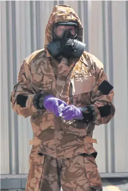  ?? Picture: PA. ?? An investigat­or in a chemical suit works behind screens on Rollestone Street, Salisbury, Wiltshire.