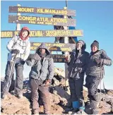  ?? COURTESY OF KRISTIE BAIR ?? Chloe Lamb, 17, left, and grandfathe­r Dr. Dean Bair, second from right, with two of their guides at Uhuru Peak, atop the 19,341foot Mount Kilimanjar­o in Tanzania. The Albuquerqu­e duo reached the summit on July 19.