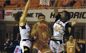  ?? MITCH ALCALA — THE ASSOCIATED PRESS ?? Texas’ Royce Hamm Jr., center, drives the lane between Oklahoma State’s Cade Cunningham, left, and Kalib Boone.