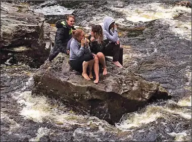  ??  ?? Stranded: The women on the rocks at the Falls of Falloch before being rescued yesterday