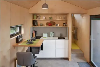  ??  ?? KITCHEN
Recessed into the storage wall is a compact but cleverly designed area for cooking