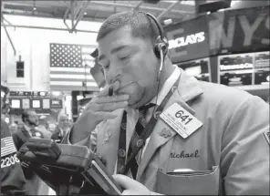  ?? AP/RICHARD DREW ?? Trader Michael Capolino works
Friday on the floor of the New York Stock Exchange.