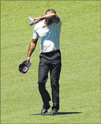  ?? Matt Slocum
The Associated Press ?? Five-time winner Tiger Woods wipes sweat from his forehead on the second hole of the third round of the Masters at Augusta National in Augusta, Ga., on Saturday.