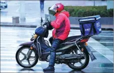  ?? YU FANGPING / FOR CHINA DAILY ?? A food delivery man in Qingdao, Shandong province, checks his orders.