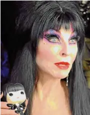  ??  ?? Horror icon Elvira appreciate­s her toy figure.