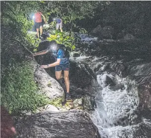  ??  ?? Participan­ts in the Hong Kong Snakes Safari scramble down rocks during a recent hike.