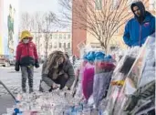  ?? YUKI IWAMURA/AP ?? A mourner lights a candle at a makeshift memorial Sunday outside a police precinct in New York.