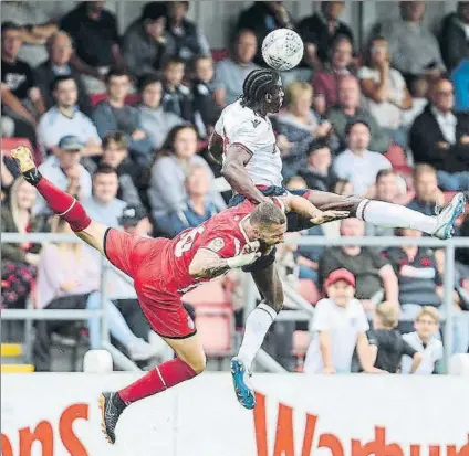  ?? FOTO: BOLTON WANDERERS F.C. ?? David Timor disputa un balón aéreo con un jugador del Bolton