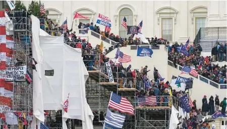  ?? JOHN MINCHILLO/AP ?? Insurrecti­onists loyal to President Donald Trump riot Jan. 6, 2021, outside the Capitol in Washington.