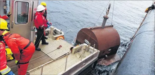  ?? PHOTO COURTESY OF THE CANADIAN COAST GUARD ?? A Canadian Coast Guard environmen­tal response crew prepares to install a cofferdam on the hull of the Manolis L. Oil collected in the old cofferdam was removed and the cofferdam was replaced.