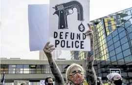  ?? Kerem Yucel, AFP/ Getty Images ?? A protester hold a sign outside Hennepin County Government Plaza at an Aug. 24 rally against police brutality and racism in Minneapoli­s after the release of a video of the shooting of Jacob Blake in Kenosha, Wis.