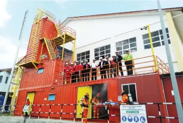  ??  ?? Zulfikri (centre), Azmi (fifth right), Mohd Nawawi (fifth left) and others give the thumbs-up during a photocall at the smoke house training packages facility.