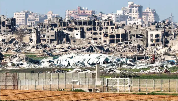  ?? — afp ?? Destroyed buildings in the Gaza Strip are pictured from a position along the border with southern Israel on Wednesday amid the ongoing conflict between Israel and the Palestinia­n militant group Hamas.