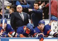  ?? Jim McIsaac / Associated Press ?? Islanders head coach Barry Trotz, left, and assistant coach Lane Lambert stand on the bench during a January game against the Flyers. The Islanders hired Lambert to succeed Trotz as coach on Monday.