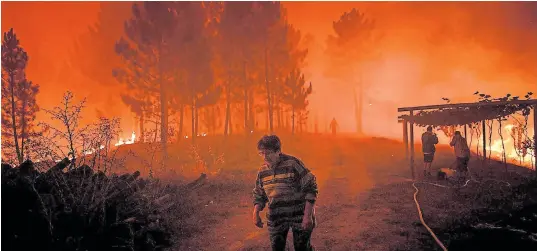  ?? Patricia de melo moreira/afp ?? Una mujer abandona, ayer, su propiedad devorada por el fuego en Amendoa