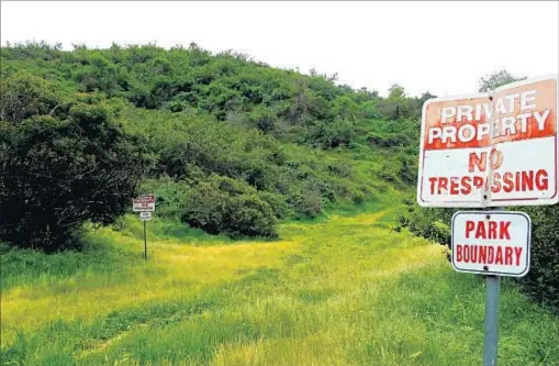  ?? Gerry Hans ?? PRIVATE-PROPERTY SIGNS are largely ignored by neighbors of the land that is for sale: about 15 acres near Griffith Park.