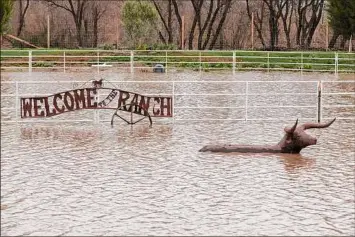  ?? Benjamin Fanjoy / Special to The Chronicle ?? A “Welcome to The Ranch” sign barely stays above flood water on Andrew Tope’s property Saturday in Salinas Calif. Salinas, like most of the state, has been battered for more than a week of heavy weather and is threatened by the flooding Salinas River.