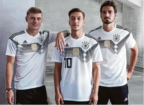  ?? Foto: dpa ?? Fototermin im Tiefgarage­n Ambiente: Die Nationalsp­ieler (von links) Toni Kroos, Mesut Özil und Mats Hummels präsentier­en das neue Trikot der deutschen Mannschaft für das WM Turnier 2018 in Russland.