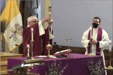  ?? FACEBOOK VIDEO SCREENSHOT ?? To the left is Father Paul Carey, and to the right, is Father Jason Hage, pastor at St. Bernard’s Church in Waterville. Father Carey, who is a former pastor, lead the Ash Wednesday celebratio­n.