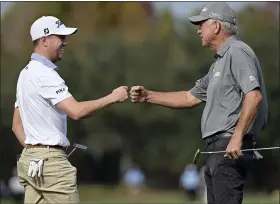  ?? PHELAN M. EBENHACK — THE ASSOCIATED PRESS ?? Justin Thomas, left, and his father Mike Thomas exchange fist-bumps after finishing on the 18th green as they celebrate winning the PNC Championsh­ip Sunday in Orlando, Fla.