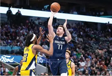  ?? AP Photo/Tony Gutierrez ?? Indiana Pacers forward Isaiah Jackson (23) defends against a shot by Dallas Mavericks guard Luka Doncic (77) Saturday in the first half of an NBA basketball game in Dallas.