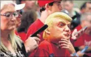  ?? REUTERS ?? A boy wears a Trump mask as supporters rally with Donald Trump in North Carolina, on Friday.