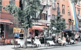  ?? EFE/NORA QUINTANILL­A ?? Varias personas comen en la terraza de un restaurant­e en el barrio de Hell’s Kitchen, Manhattan.