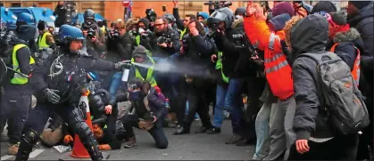  ??  ?? CLASH: A riot police officer fires tear gas at protesters in Paris yesterday. At least 168 were arrested in the French capital