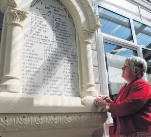  ?? PHOTO: SHARON REECE ?? Remembered . . . Southland researcher Ann Robbie reads the names of the former Makarewa Presbyteri­an Church members who served during World War 1, listed on the honour board at Makarewa School.