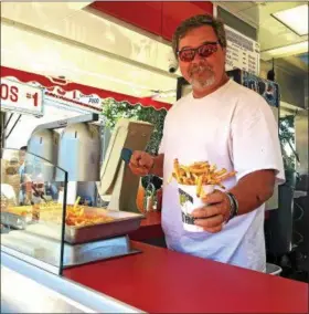  ?? CARRIE GARLAND — FOR THE NEWS-HERALD ?? Jack Richardson’s family has been serving up fresh fries and other food at Fairport Mardi Gras for more than 50 years.