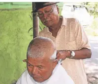  ??  ?? Auf der indonesisc­hen Insel Java wartet dieser Friseur im Bahnhof auf seine Kunden.