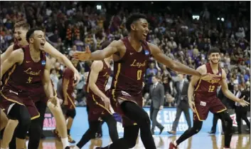  ??  ?? Loyola-Chicago players celebrate after winning a regional final NCAA college basketball tournament game against Kansas State on Saturday in Atlanta. Loyola-Chicago won 78-62. AP PHOTO/DAVID GOLDMAN