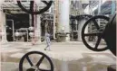  ?? — Reuters ?? A worker walks past oil pipes at a refinery in Wuhan, Hubei province, China.