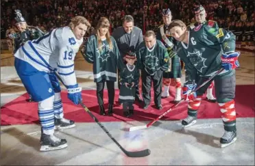  ?? KAZ NOVAK, THE HAMILTON SPECTATOR ?? Cpl. Nathan Cirillo’s son, Marcus, centre, drops the ceremonial puck between the Bulldogs’ Captain Gabriel Dumont, right, and the Marlies Troy Brodie.