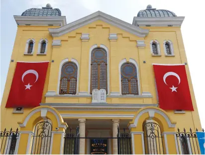  ??  ?? TURKISH FLAGS hang on the facade of the restored Great Synagogue before a re-opening ceremony in Edirne, in 2015.