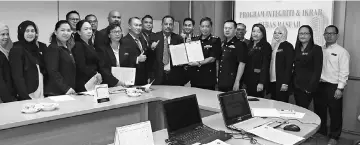  ??  ?? Othman (sixth right) hands over IBR pledge to Hendera while others look on.