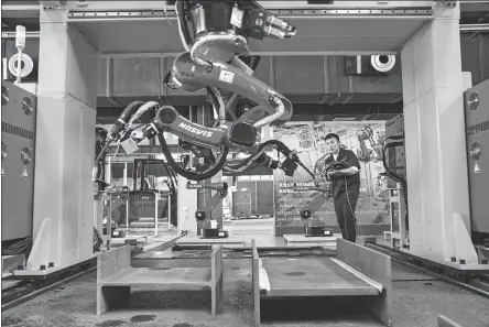  ?? PROVIDED TO CHINA DAILY ?? A Siasun employee conducts tests on a set of robotic arms at a production facility in Shenyang, Liaoning province, in August.