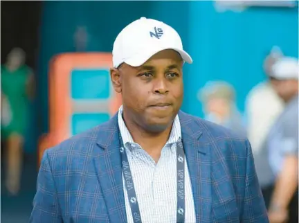  ?? DOUG MURRAY/AP ?? Dolphins general manager Chris Grier, pictured walking onto the field before a game against the Jets on Jan. 8 in Miami Gardens, begins free agent negotiatio­ns Monday with a chance to make another big splash after trading for Jalen Ramsey.