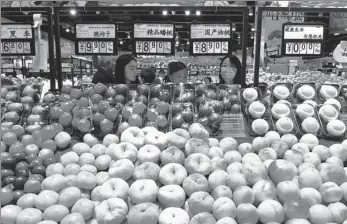  ?? JIA MINJIE / FOR CHINA DAILY ?? Shoppers buy fruit at a supermarke­t in Shijiazhua­ng, Hebei province.