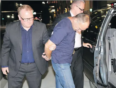  ?? MIKE DREW/ CALGARY SUN/ QMI AGENCY ?? Douglas Garland, charged in the disappeara­nce of Nathan O’Brien and his grandparen­ts, Kathy and Alvin Liknes, is escorted by Calgary City Police detectives to the arrest processing unit in Calgary on July 14, 2014.